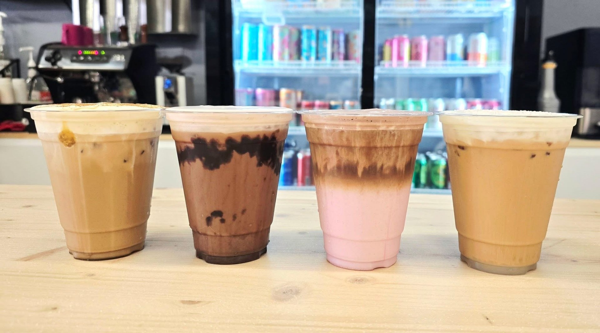 Four specialty iced drinks lined up on the counter