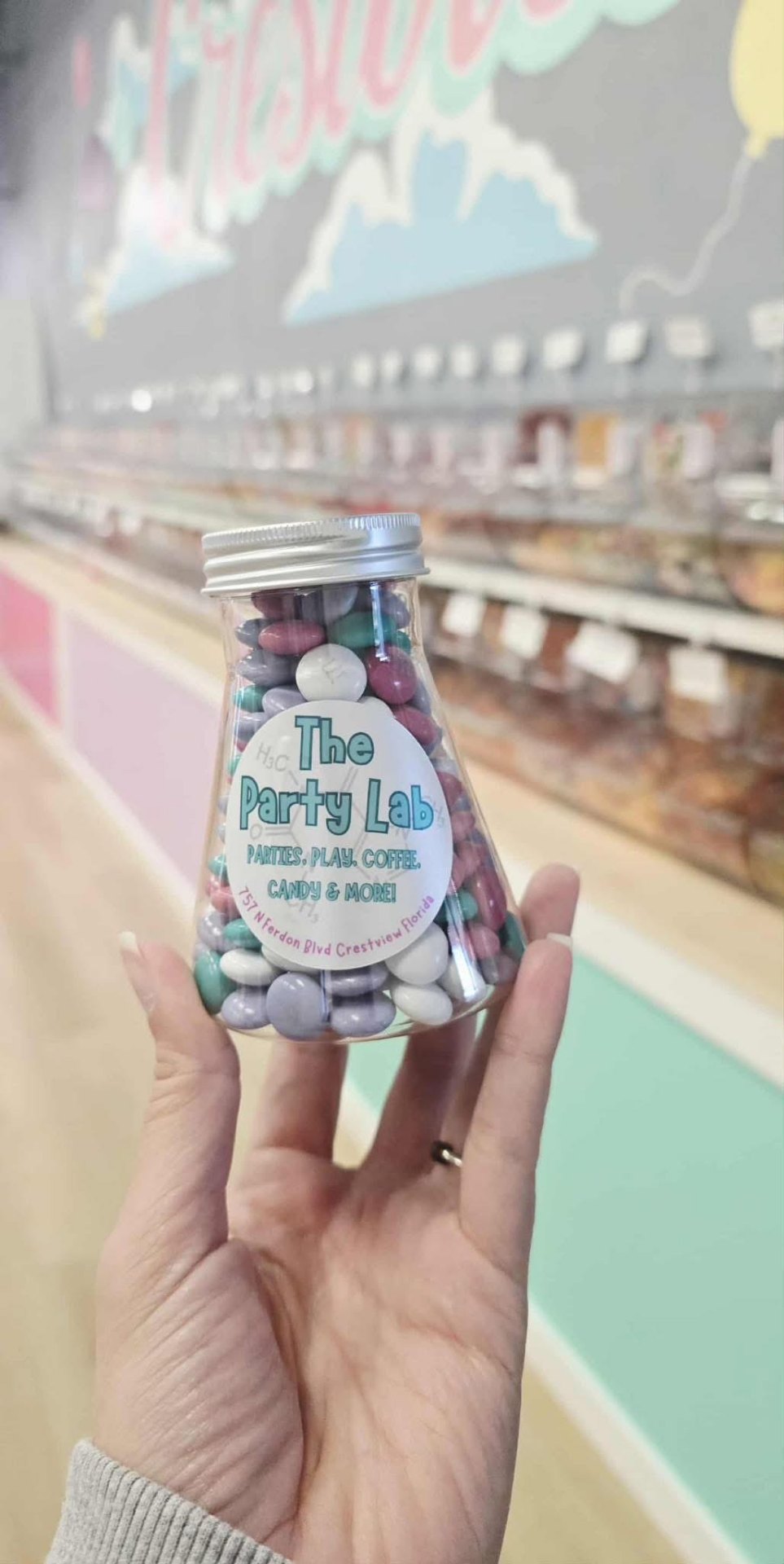 Beaker filled with pastel candies in hand
