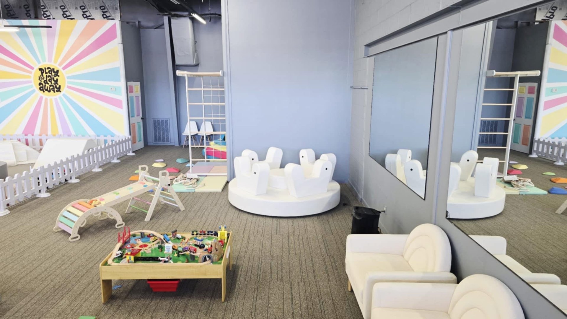 Toddler zone with climber, ride-ons and soft seating